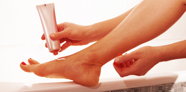 a woman using foot lotion